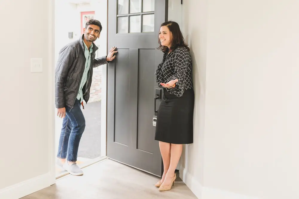 Agent welcoming a client into a freshly renovated home