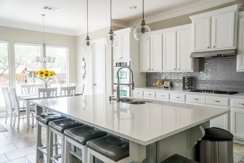 Bright renovated kitchen with a white island and pendant lights